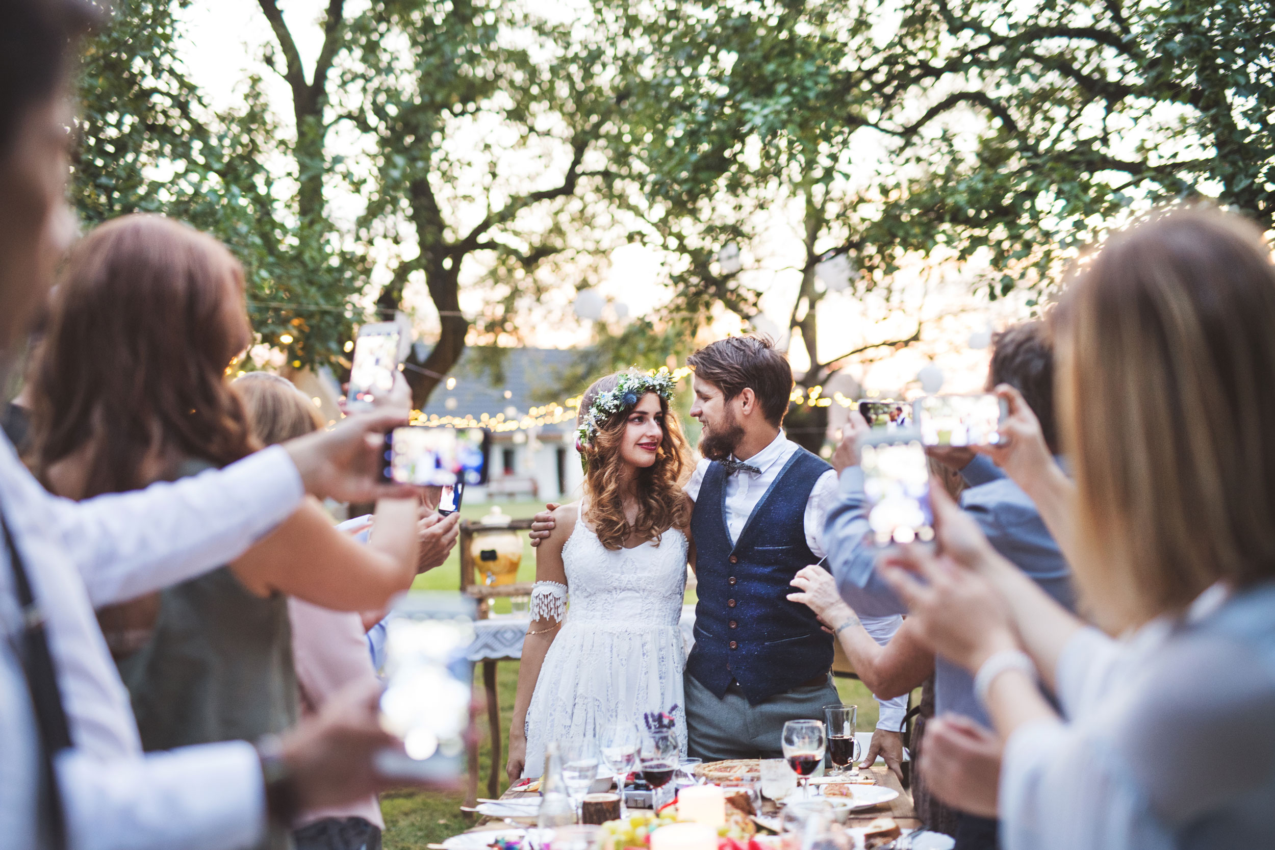 Guests taking photo of the bride with smart phones