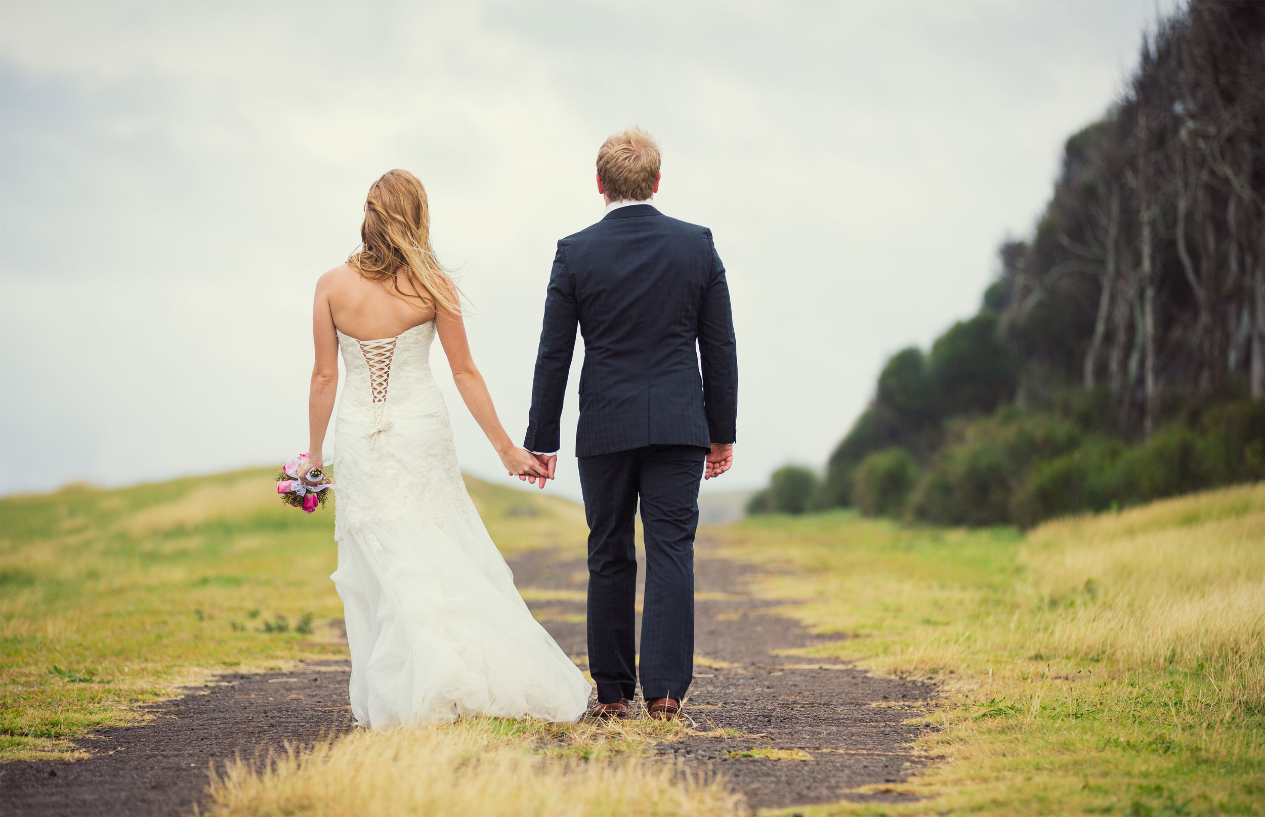 Bride and groom with back to camera enjoying the view