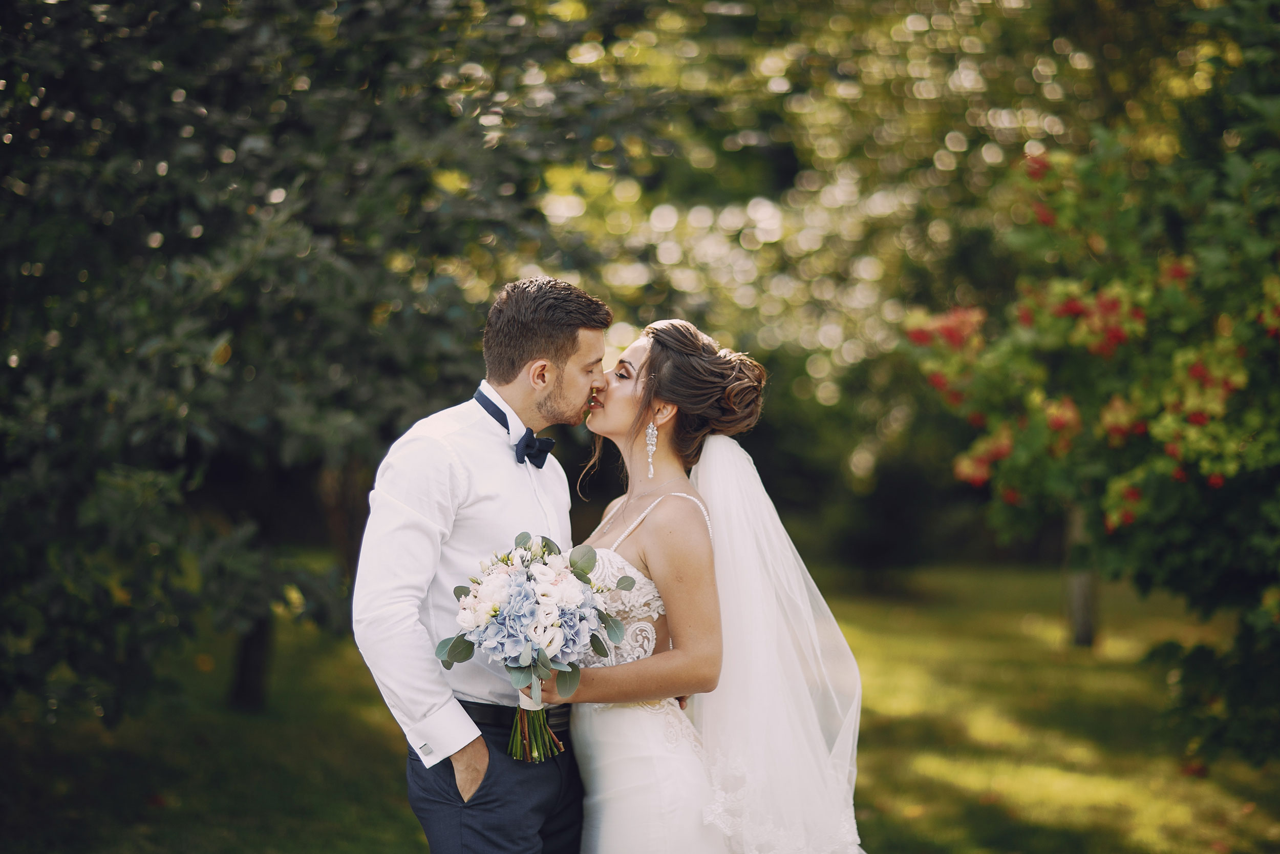 bride and groom kissing at outside wedding venue