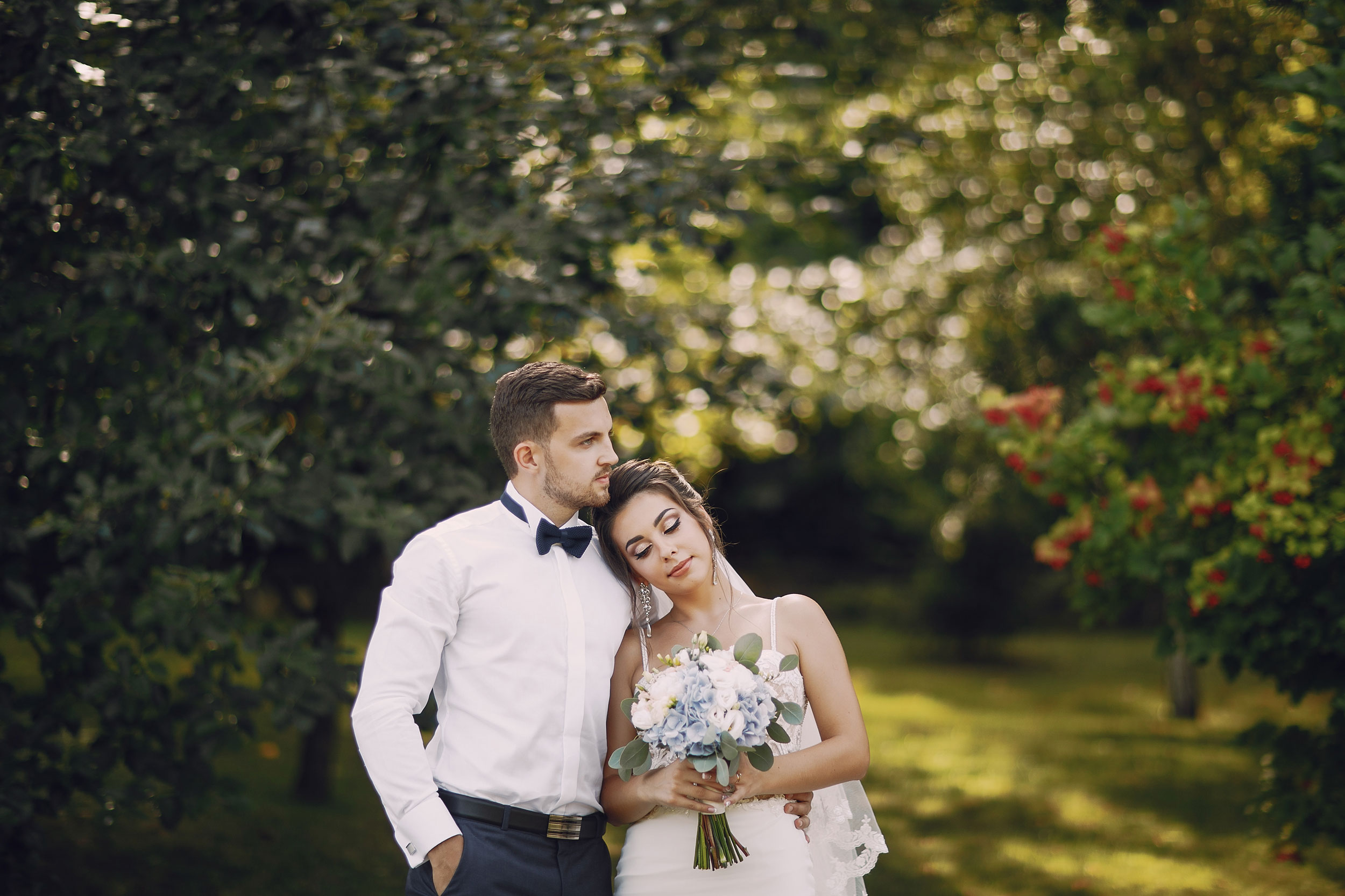 bride resting head on grooms shoulder outside